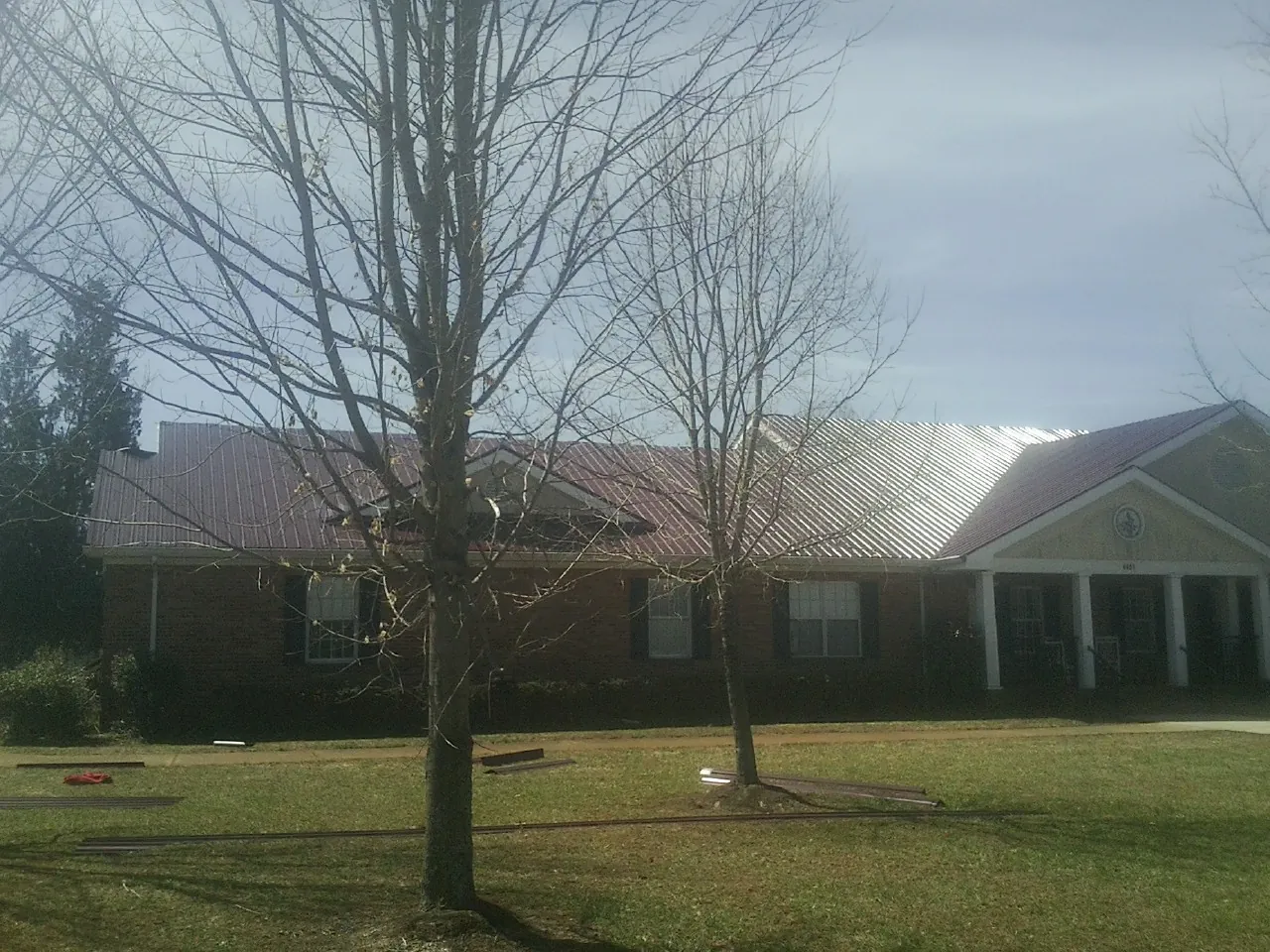 Red metal roof on a brick building seen from the front lawn in Deal Island
