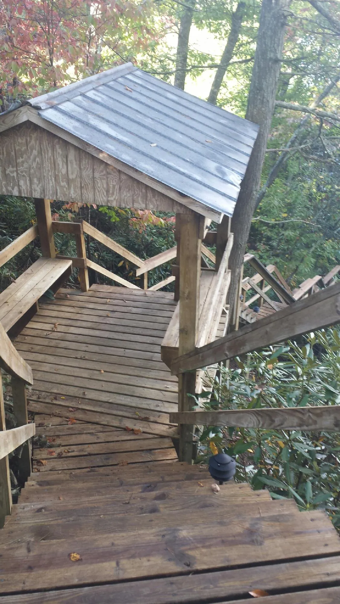 Metal roofed shelter over wooden steps on a wooded walkway — Skylight Repair & Installation work by our crew in Deal Island