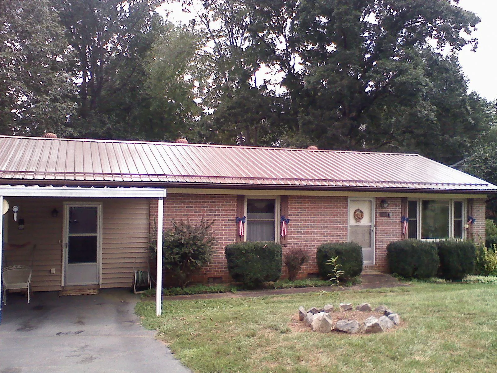 Bronze metal roof and carport on a brick ranch home — Roof Repair work by our crew in Deal Island